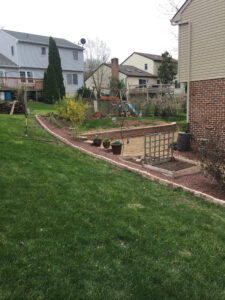 red stone gravel pathway lining various plant beds and pots, spring cleanup checklist