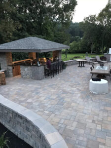 newly finished large patio with short walls surrounding it and flowerbeds bordering the walls